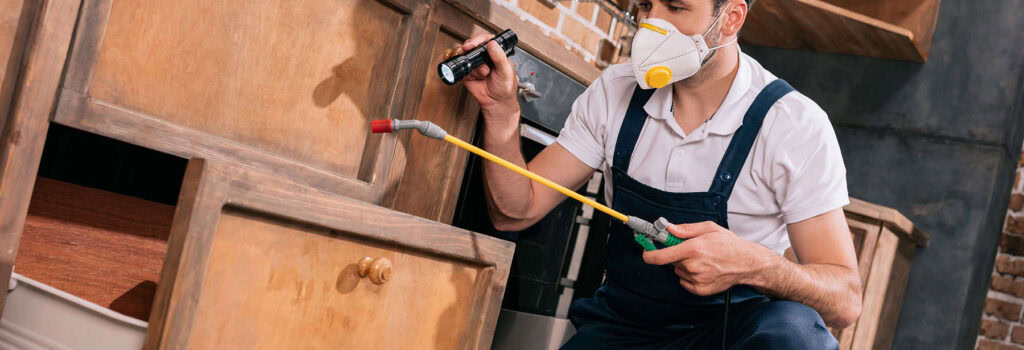 Technician applying a post-construction termite treatment around a home